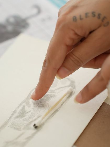 A close-up of a student using cotton swabs for delicate blending in a pencil sketch. We teach various techniques to achieve professional results.