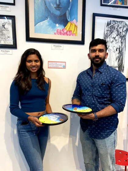A couple smiling with their finished resin beach art pieces. It's a fantastic way to spend quality time together and create something beautiful.