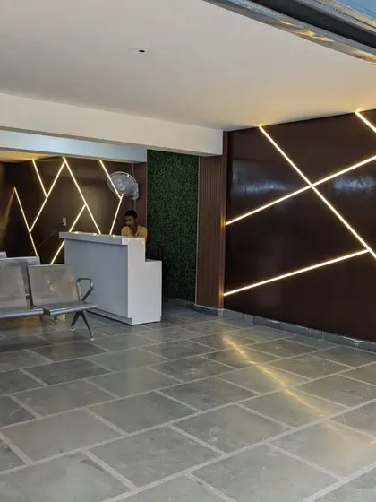The realized design of a waiting area, featuring a striking wall with geometric, backlit patterns. This project shows how we translate our bold design concepts into real, impactful commercial spaces.