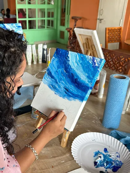 A close-up of a participant creating dynamic ocean waves on her canvas. The workshop teaches how to use different tools to achieve stunning effects.