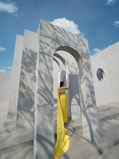 A yellow ruffle corset sari, showcasing a blend of modern trends. The delicate pearl embellishments on the corset add a touch of elegance to the playful silhouette.