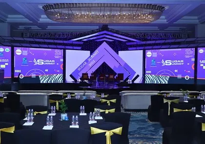 A grand stage for the 'Sugar Summit 2023.' The design uses geometric shapes, a mirrored ramp, and multiple large LED screens to create a futuristic and high-impact setting for this major industry conference.