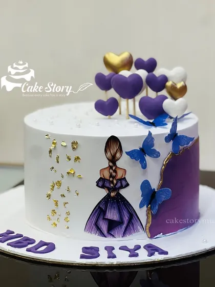 A beautiful cake for a little queen. This design features a girl in a purple dress, with purple hearts, blue butterflies, and gold leaf accents.