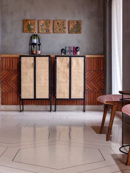 A closer look at the material palette, with the hexagonal patterned floor, rattan and metal cabinets, and the textured brickwork. Each element was chosen to contribute to the office's industrial-chic aesthetic.