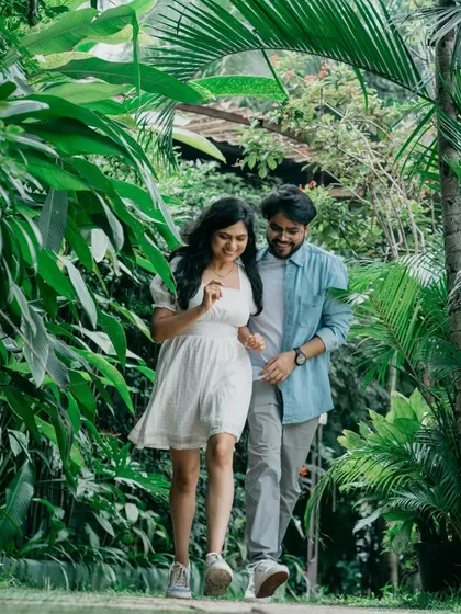 A casual stroll through a lush, tropical pathway in Bangalore. This photo captures the couple in motion, creating a dynamic and natural pre-wedding portrait that feels authentic and unposed.