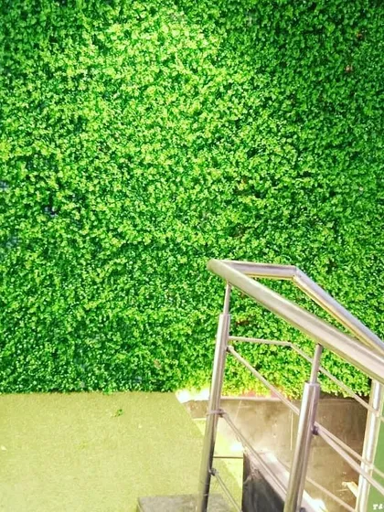 A simple, clean artificial green wall installation at the entrance of a commercial establishment. It's an effective way to make a space feel more upscale and welcoming.