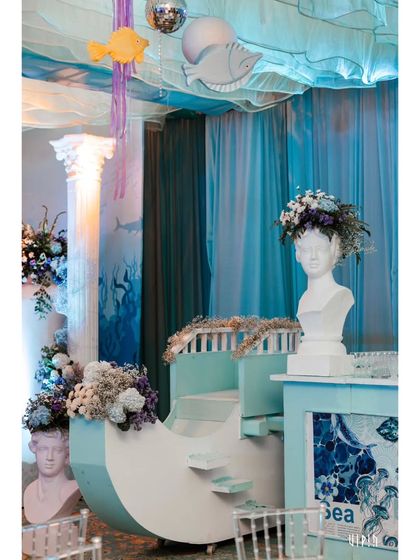 A beautiful bar or counter setup with a boat-like design and busts adorned with floral crowns. This shows how I can transform any functional area into a piece of thematic art.