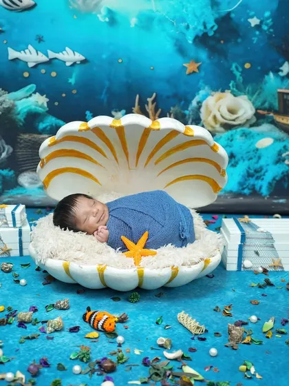Your little one is a precious pearl, and we love creating magical worlds for their first photoshoot. This newborn session features an imaginative underwater theme, with the baby sleeping peacefully in a giant seashell. Every detail, from the coral backdrop to the tiny starfish, is designed to create a whimsical and unforgettable portrait.