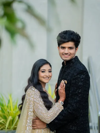 A classic, elegant portrait of the couple. This shot is perfect for showcasing their full outfits and their confident smiles.
