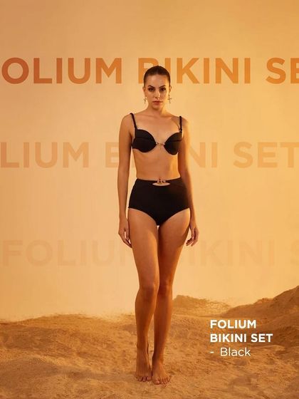 The Folium Bikini Set in black by Tizzi, presented in a clean, e-commerce friendly format against a warm-toned studio background.