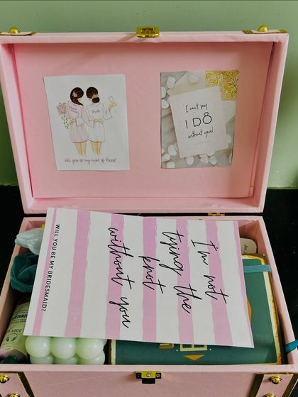 The moment of reveal for a bridesmaid proposal. The card inside the trunk reads, "I'm not tying the knot without you," a heartfelt message for a dear friend.