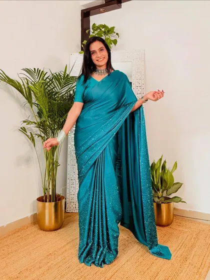 This teal blue satin saree with delicate stonework is so elegant. The color is stunning and the fabric drapes beautifully, making it a great choice for a wedding guest outfit.