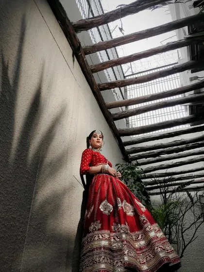 A creative angle showcasing the grandeur of the red bridal lehenga. The styling is designed to look magnificent from every viewpoint.