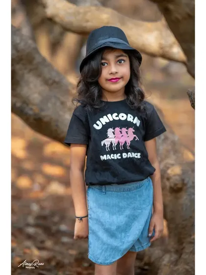 A stylish portrait for a seventh birthday. Brishka shows off her cool side with a fedora hat and a unicorn t-shirt, proving that kids' photoshoots can be fashionable and fun.