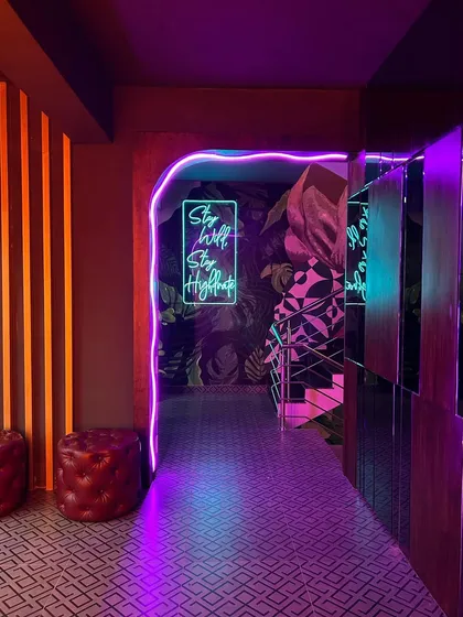 The grand entry passage at 'Highdrate,' where neon and mirror effects create a futuristic and exciting welcome for guests.