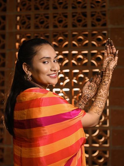 A beautiful portrait of the bride Rupa, her smile as vibrant as her colorful outfit and her lovely mehendi.