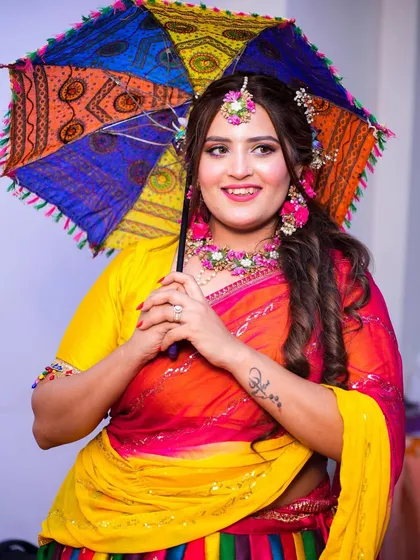 A playful shot with a colorful umbrella, perfectly matching the festive vibe of her Mehendi ceremony.