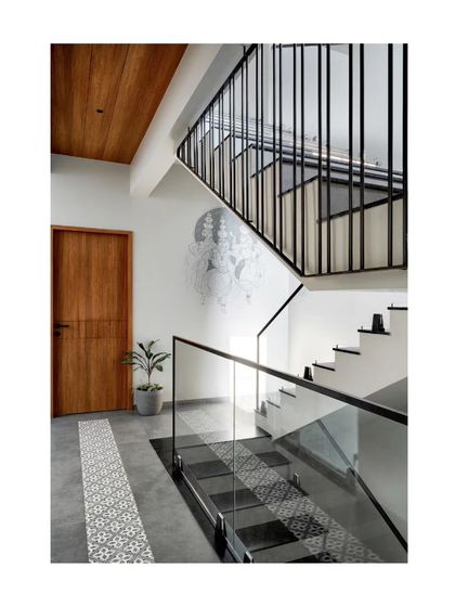 The staircase in this compact home features a modern design with glass railings and patterned tiles, creating a light and open feel.
