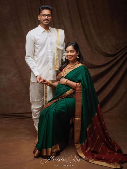 An elegant maternity portrait celebrating South Indian heritage. The couple's traditional veshti and saree create a graceful and culturally rich photograph.