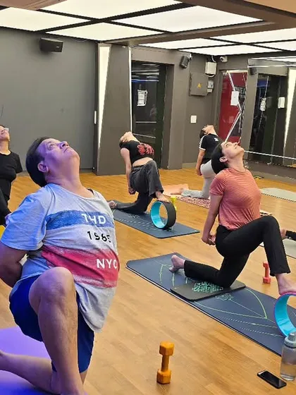 In my studio classes, we often use props like the yoga wheel to explore poses more deeply and safely. Here, my students are in a heart opening backbend, using the wheel to support their spine, enhance flexibility, and build core strength.