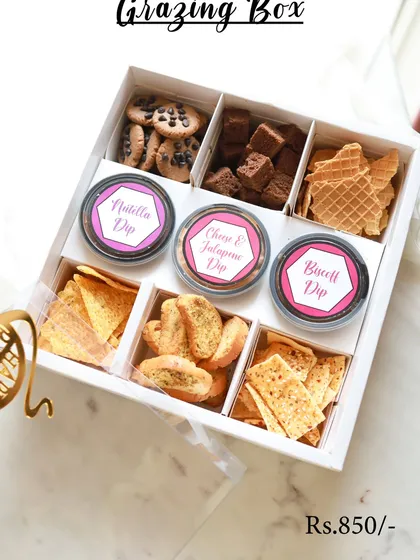 My signature Grazing Box is the perfect mix of sweet and savory. It includes Chocochunk cookies, brownie bites, assorted crackers, and three delicious dips: Nutella, Cheese & Jalapeno, and Biscoff.