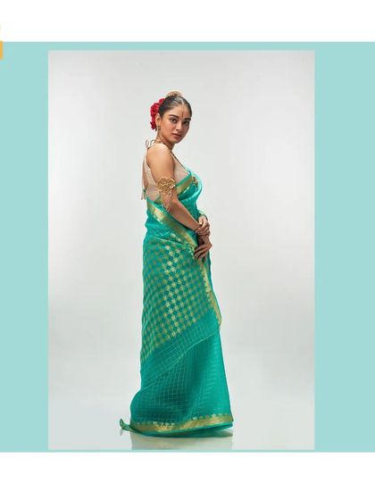The side profile of the light sea green saree, showcasing its elegant drape.