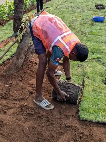 A close look at the technique of unrolling and placing the turf carpet for a seamless finish.