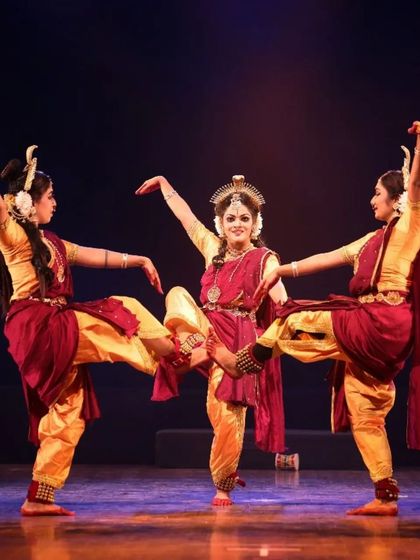 A beautifully synchronized moment from "Shrishti Stithi Laya". The three dancers move as one, their forms highlighted by dramatic spotlights, embodying the principles of creation, preservation, and dissolution.