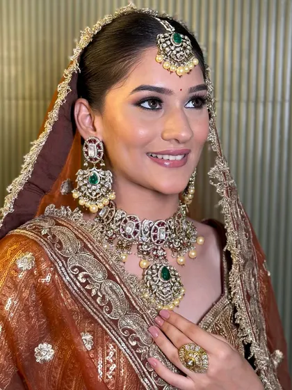 A radiant bride wearing one of our signature emerald and polki bridal sets. The combination of green stones and uncut polki diamonds creates a look that is both classic and fresh.