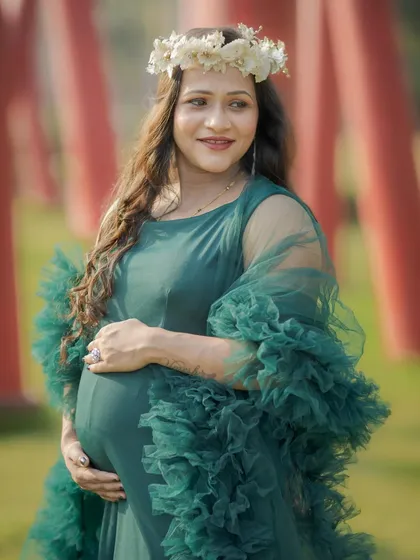 A lovely three-quarter portrait capturing the happy glow of this expecting mother, framed by a sunny, natural background.