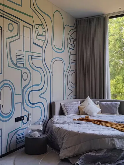 The mural's lines curve around the circular bed, creating a custom look that feels intentional and fully integrated with the room's unique furniture and layout.