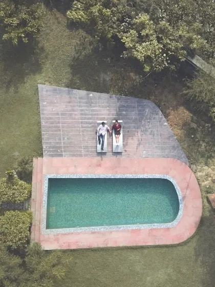 An aerial drone shot gives a completely different perspective. Here, the couple relaxes by the pool, creating a serene and stylish image that feels like a scene from a movie.