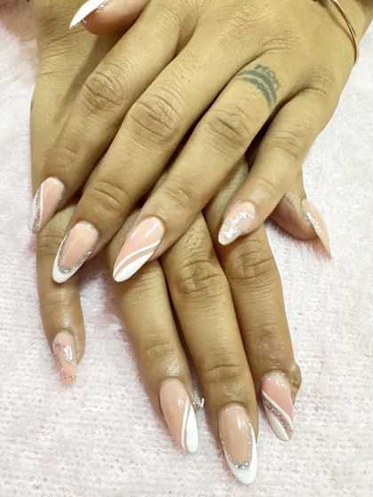 A soft and elegant design featuring a classic French tip with delicate white and silver glitter swirls on accent nails.