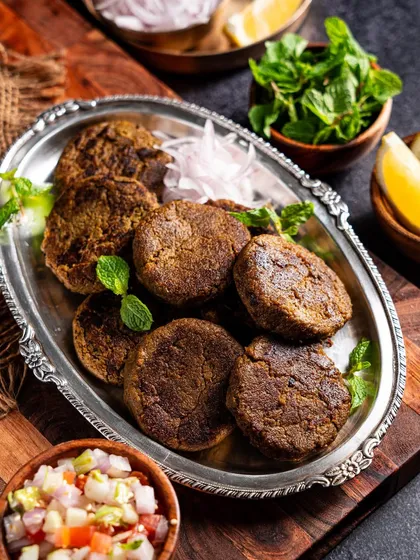 A different angle for Cloudchef's kebabs, this time on an ornate silver platter with fresh mint and onions. This styling elevates the dish, making it suitable for premium marketing.