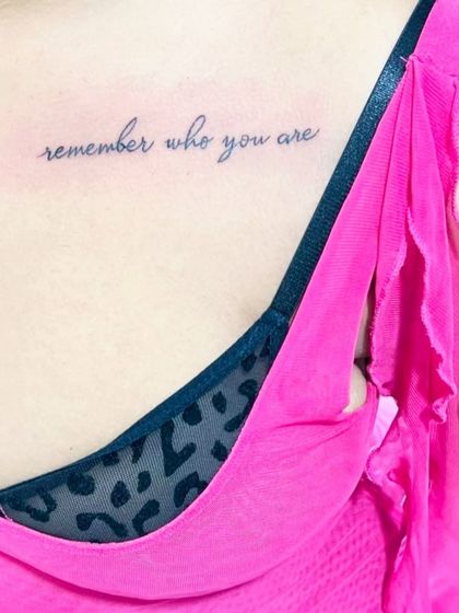 "Remember who you are" script tattoo placed near the collarbone. A beautiful and personal reminder inked in a delicate font.