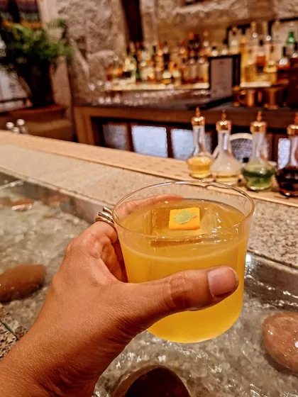 A refreshing cocktail served over a unique, water-filled bar counter at Loya.