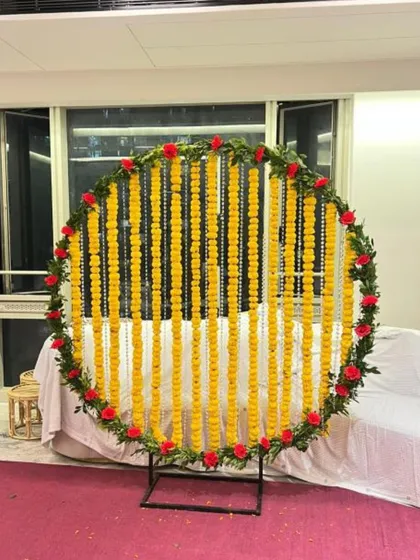 A modern take on traditional decor, this circular backdrop uses classic marigold strings within a contemporary frame.