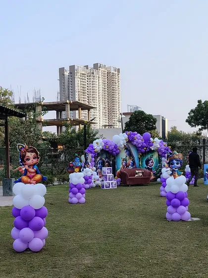 A wide shot of the park area decorated for the Krishna-themed event, with balloon pillars guiding the way.