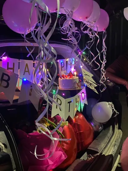 A closer look at another car boot decoration. You can see the birthday cake placed carefully among the balloons and streamers, ready for the celebration.