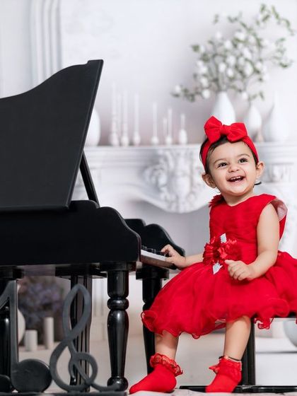 She leaves a little sparkle wherever she goes. This girl's joyful laugh is the highlight of her piano session in our white, elegant studio.