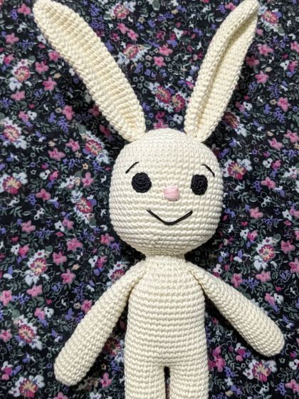 A simple, classic white bunny with a sweet, smiling face.