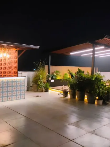 The bar and adjacent pergola at night, forming a complete entertainment zone on this spacious terrace.