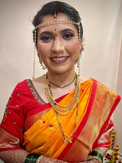A smiling bride ready for her wedding. The pearl mundavalya and traditional jewelry are key features of this classic Maharashtrian style.