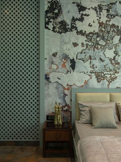 A close-up detail of the bedside in the artistic bedroom, highlighting the contrast between the rough, textured accent wall and the smooth, patterned lattice screen.