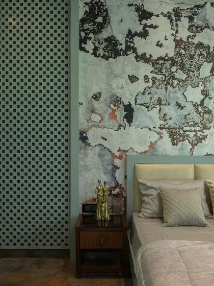 A close-up detail of the bedside in the artistic bedroom, highlighting the contrast between the rough, textured accent wall and the smooth, patterned lattice screen.