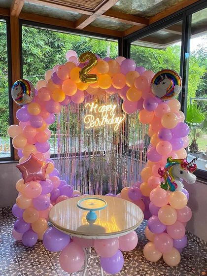 A unicorn-themed ring backdrop for a 2nd birthday, using a bright pastel color palette.