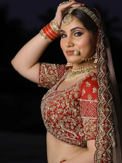 A confident pose from a bride ready for her big day. The makeup is bold and traditional, with a matha patti and nath completing the classic Punjabi bridal look.
