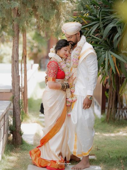 A peaceful embrace in a garden setting. This portrait captures a feeling of comfort, safety, and deep affection between the newly married couple.
