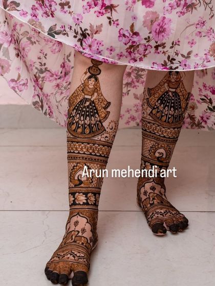 A full-leg mehendi design featuring portraits of women carrying pots, a beautiful and unique theme.