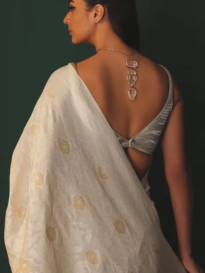 The beauty is in the details. This shot highlights a stunning carved necklace worn with a backless blouse and a handwoven saree, showcasing how accessories can elevate an entire look.